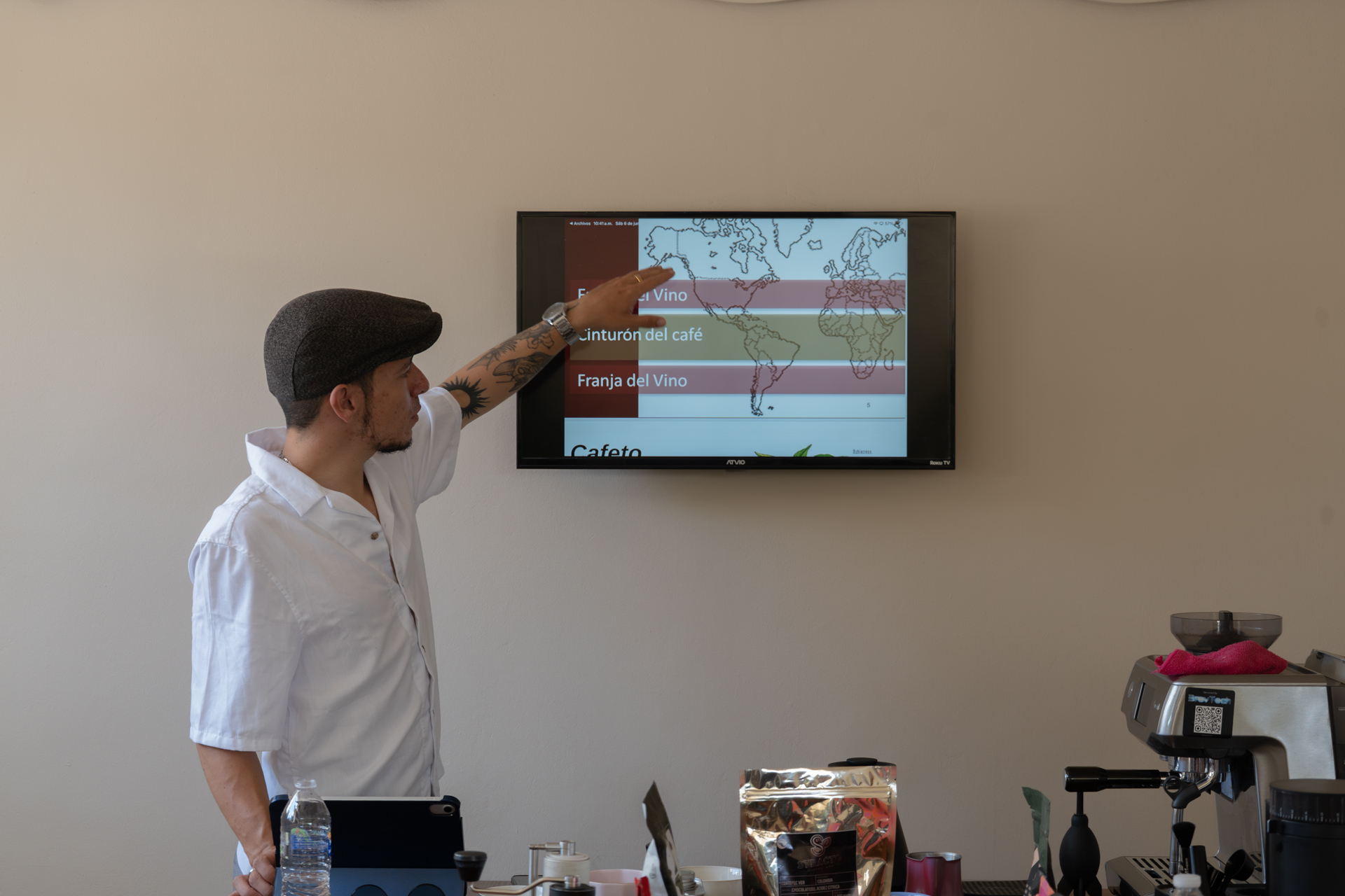 Instructor señalando el cinturón cafetero en el mapa mundial