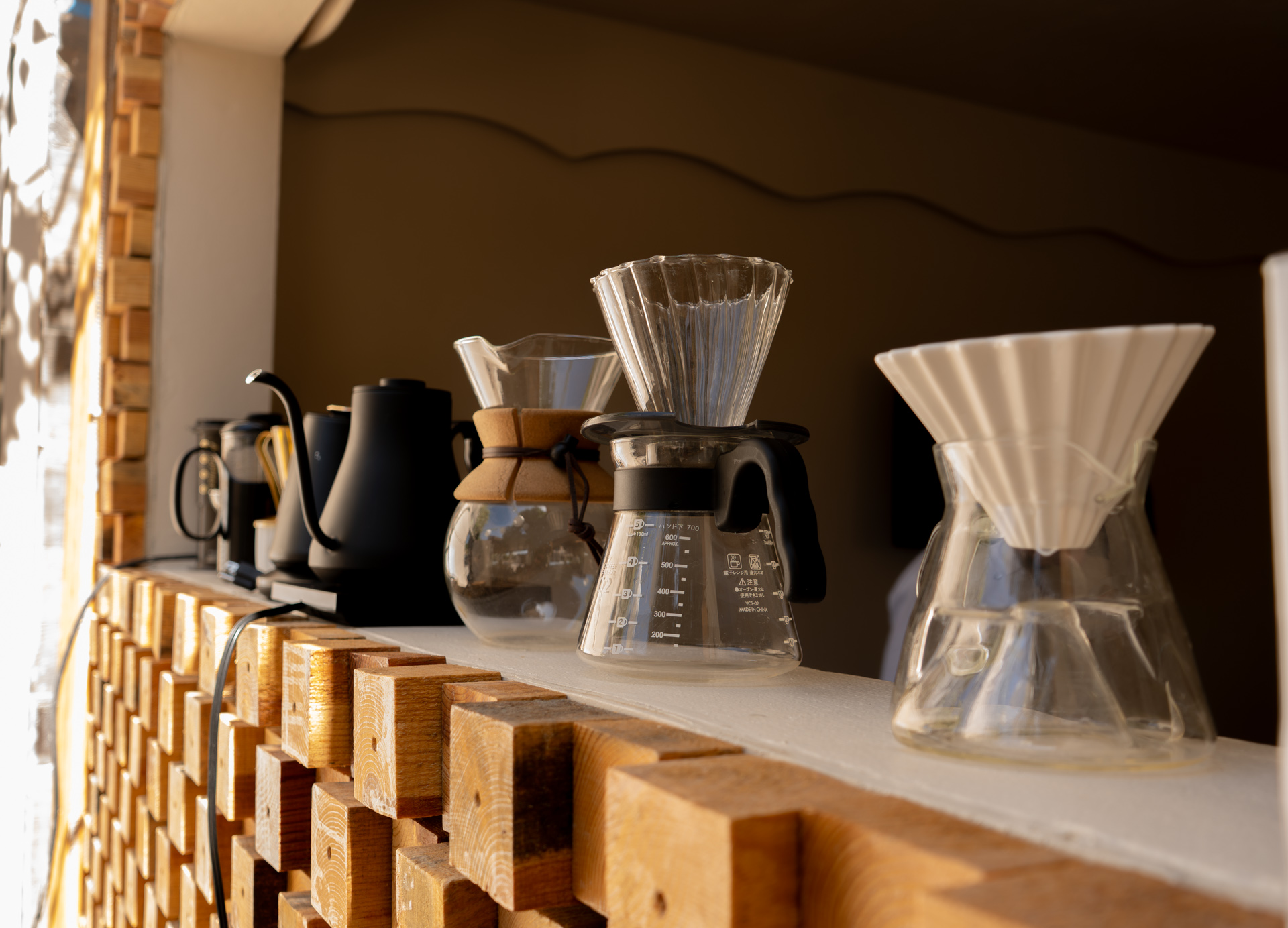 Drippers de pour over en repisa de madera con luz solar