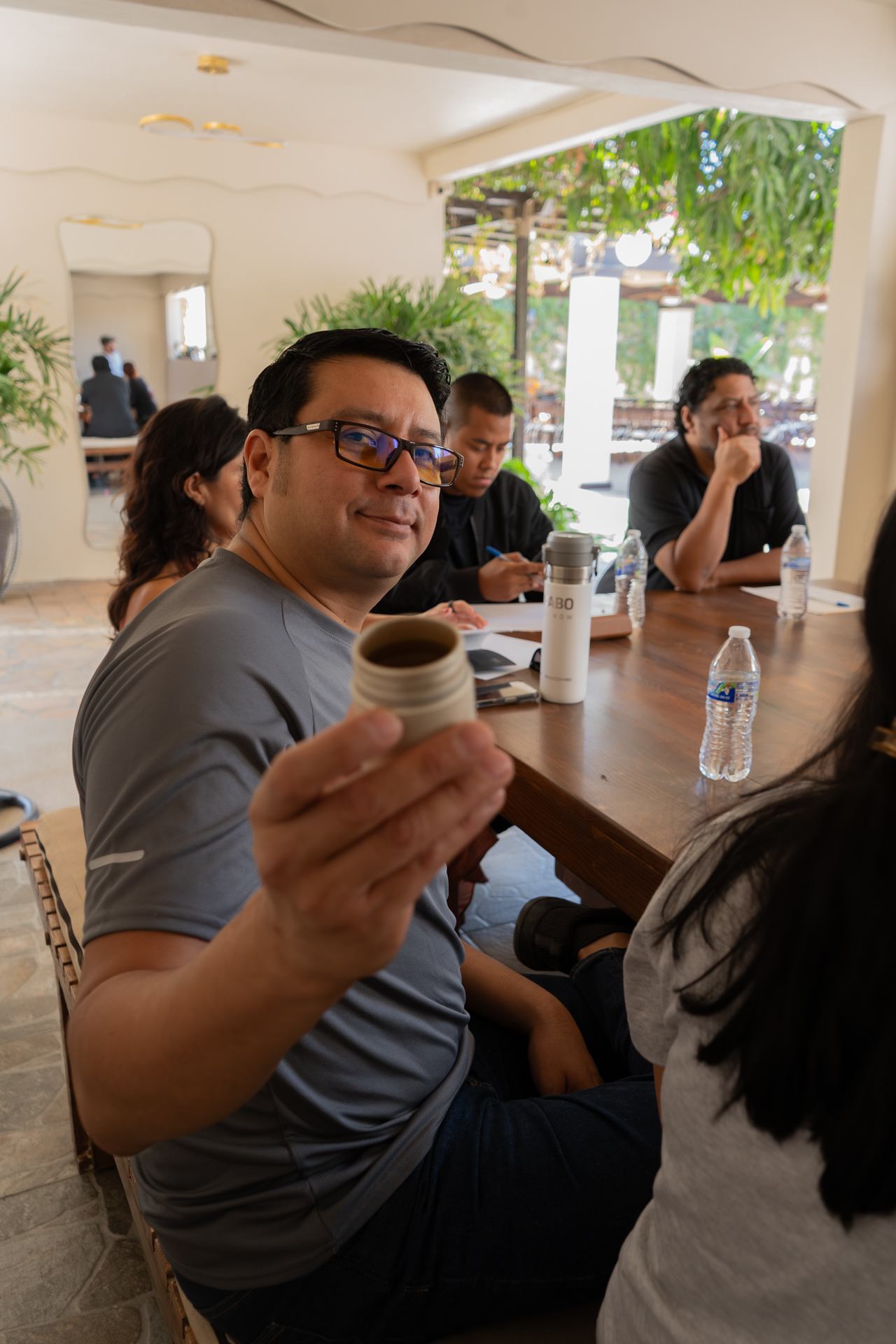 Estudiante sosteniendo pequeña taza durante la práctica grupal