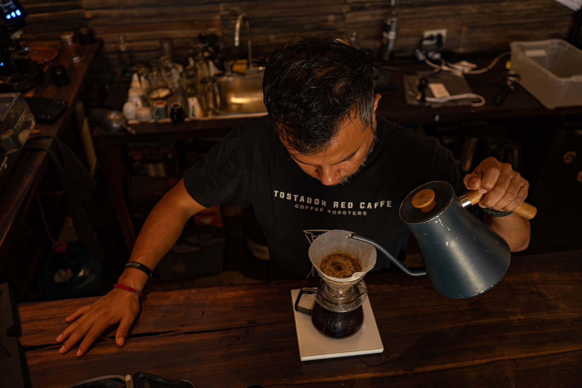 Vista superior del barista con kettle y dripper pour over