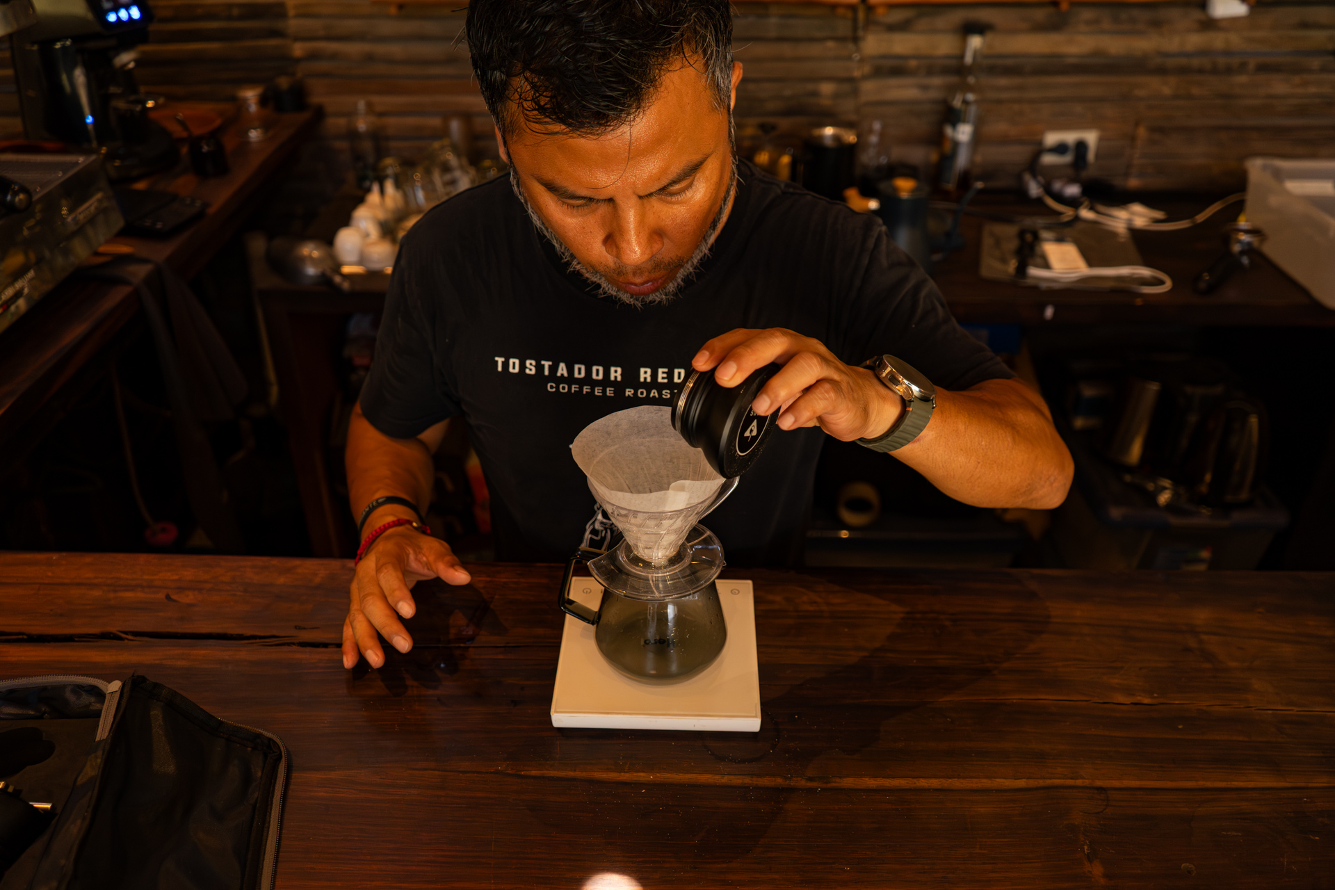 Barista agregando café molido al dripper pour over
