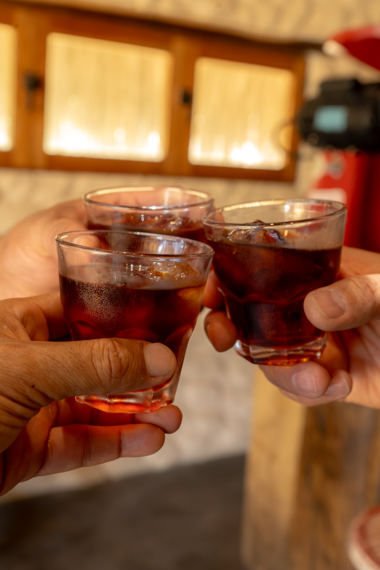 Tres manos brindando con vasos de café frío