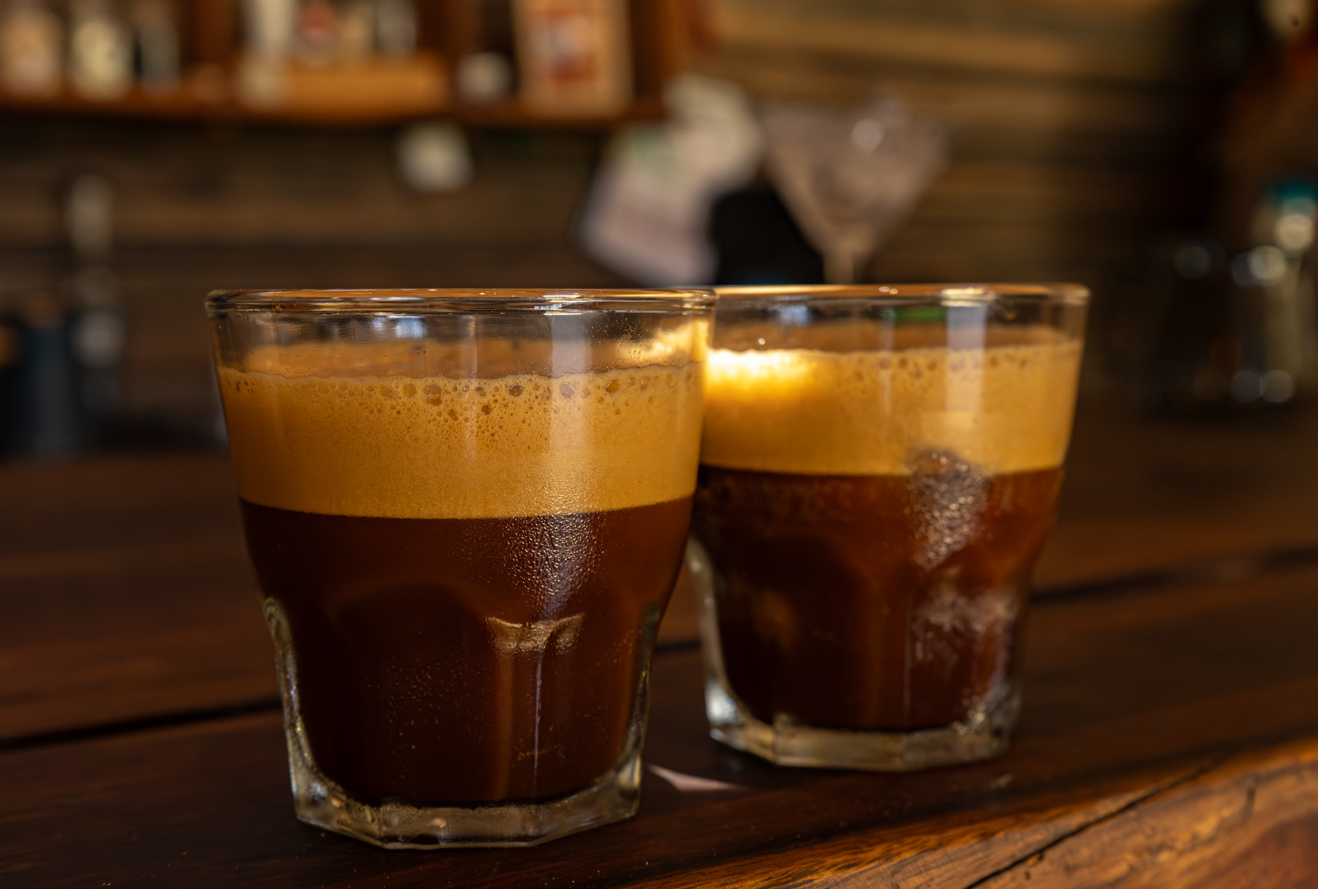 Dos shots de espresso con crema espumosa sobre la barra de madera